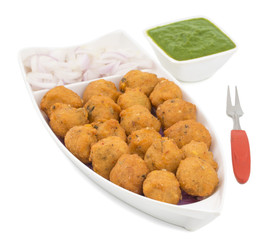 Indian Spicy Street Food Dal Vada Also Know as Moong Dal Vada, Pakoda, Pakode, Pakore, Moong Vada, Pakora or Bhajiya Served with Green Chutney or Onion isolated on White Background