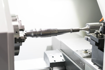Operator machining automotive part by cnc turning machine,