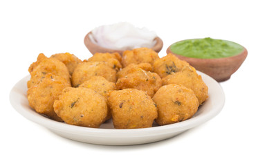 Indian Spicy Street Food Dal Vada Also Know as Moong Dal Vada, Pakoda, Pakode, Pakore, Moong Vada, Pakora or Bhajiya Served with Green Chutney or Onion isolated on White Background