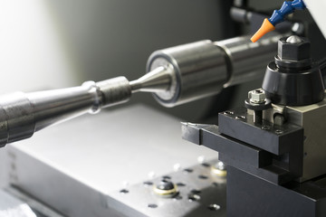 Operator machining automotive part by cnc turning machine,