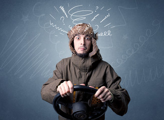 Young man holding black steering wheel with white scribbles around him