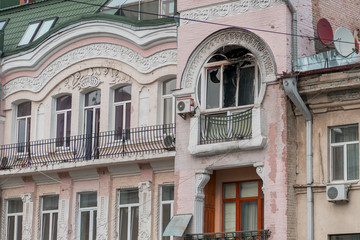 Naklejka premium Facade of the house after the fire. Blackened from soot wall around the burnt-out apartment. Flames damaged the windows and balconies. Apartment after a fire.