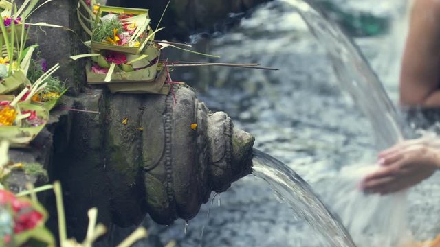 Balinese hindu people praying in the holy springs. Tirta Empul temple - October 2017: Tampaksiring, Bali, Indonesia