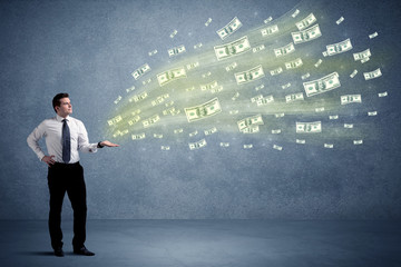 Fototapeta premium Caucasian male in business suit holding money,which flies through his hands