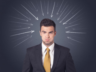 Young businessman with arrows pointing to his head 