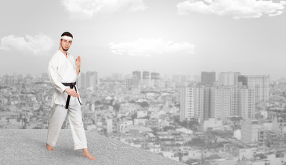 Young karate trainer doing karate tricks on the top of a metropolitan city
