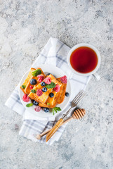 Healthy summer breakfast, baked french toasted bread sticks with fresh berry and honey, morning...