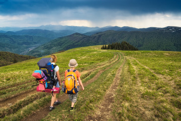 Family hikers on a road in a mountain valley
