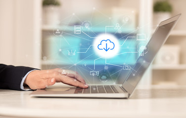 Business woman in homey environment using laptop with  online storage and cloud technology concept
