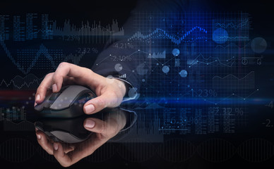 Hand using wireless mouse with financial concept on dark background
