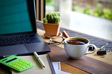 Desk work coffee cup and laptop notebook pen on wooden table