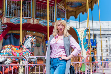 Nice beautiful fashionable woman in an amusement park. Pretty , middle age lady having fun at an amusement park. Joy in adult life 