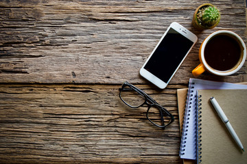 Coffee cup hot and notebook pen on wooden table desk 