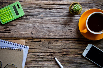 Coffee cup hot and notebook pen on wooden table desk 