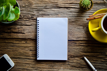 Coffee cup hot and notebook pen on wooden table desk 