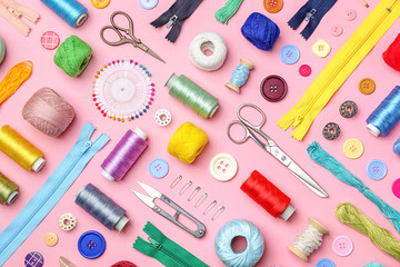 Composition with threads and sewing accessories on color background, flat lay
