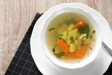 Bowl with delicious hot broth on table, top view. Cold treatment