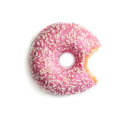 Delicious bitten doughnut with sprinkles on light background
