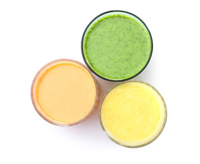 Glasses with delicious detox smoothies on white background, top view