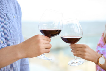 Young romantic couple with glasses of red wine outdoors