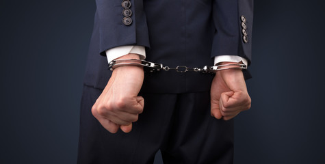 Close now arrested men hand with dark background and handcuffs
