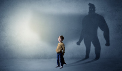 Cute kid in a room with plush on his hand and hero shadow on his background
