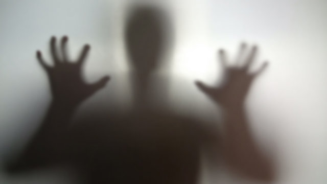 Mysterious silhouette with hands up, going to scare, nightmare person in stress