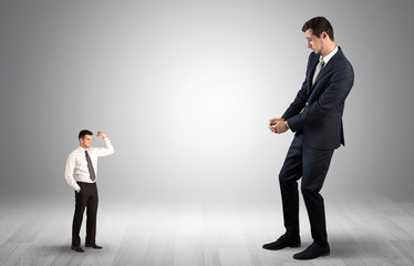 Big debutant young businessman scared of small strong businessman
