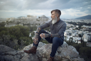 Porträt eines bärtigen Mannes, der in Athen auf dem Berg gegenüber dem Akropolis sitzt und den...