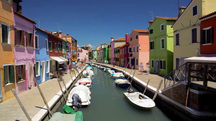 Fototapeta na wymiar Tourists viewing brightly colored houses in Burano island street, Venice