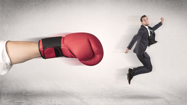Businessman gets fired from his job by a huge hand in boxing gloves