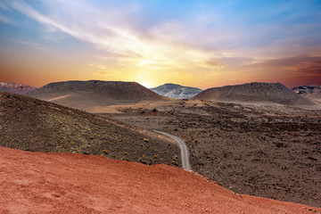 A road crossing the Timanfaya National Park at sunset. Lanzarote, Canary Islands, Spain.