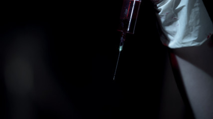 Scary blood syringe in doctors hand, deadly infection danger, terrible crime