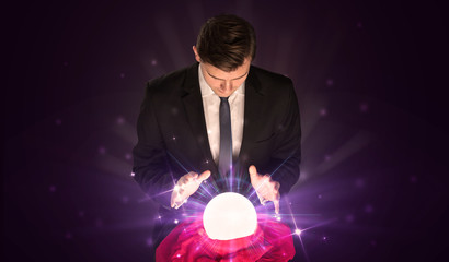 Young businessman sitting with crystal ball in action