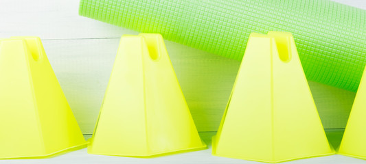 yellow fences for fitness in the gym and on the street and green mat for gymnastics, on a gray background