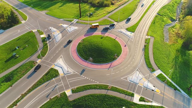 Early morning rush hour at busy city roundabout, time lapse aerial view.
