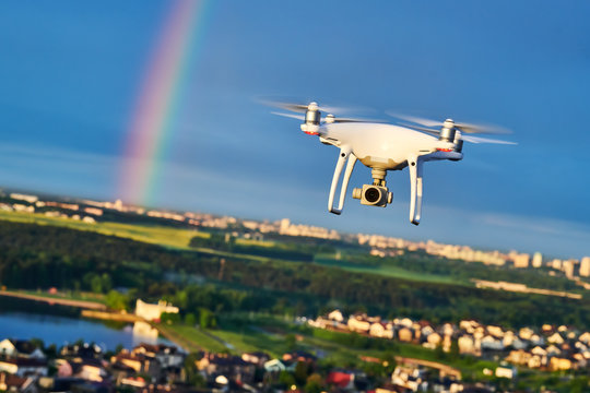 drone flying over city with digital camera at rainbow