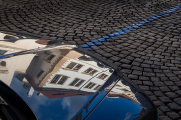 Obraz premium Detail of a car with reflection of the historical houses. Prague, Czech republic