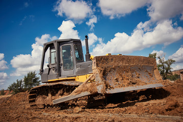 bulldozer earthmover working with clay or soil © Kadmy
