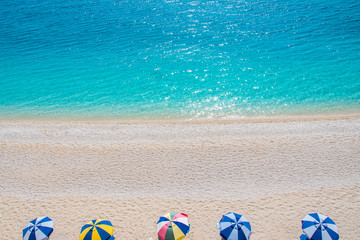 Colorful beach umbrellas on a beach with crystal clear turquoise sea waters. Summer concept. Porto Katsiki beach in Lefkada ionian island in Greece
