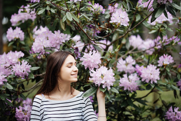 Fototapeta premium Spring, summer, beauty, healthcare. Beautiful woman among purple flowers outdoors