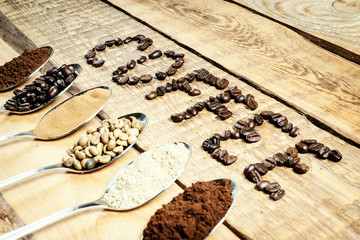 spoons with different types of coffee and an inscription on an old wooden table