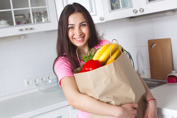 Young healthy woman with fresh vegetables on the kitchen