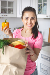 Young healthy woman with fresh vegetables on the kitchen