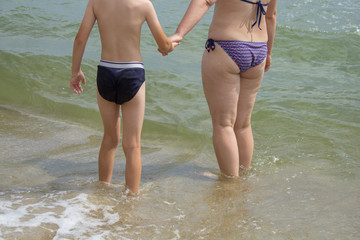 woman with a boy in water at sea