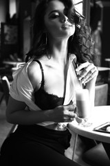 woman with dark curly hair in elegant dress sitting in elegant restaurant