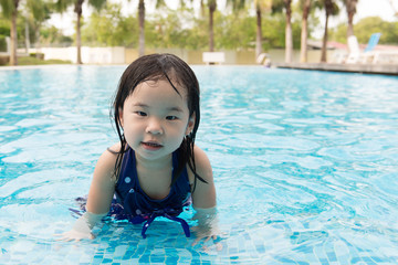 Fototapeta na wymiar Portrait of Asian little baby girl playing in swimming pool