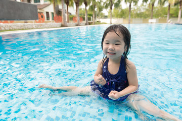 Portrait of Asian little baby girl playing in swimming pool