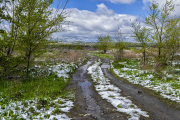 Fototapeta na wymiar Snow in spring. Snow in may. Country road. Central Asia, Kazakhstan. Spring landscape