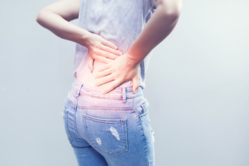 Portrait of young woman touching her back with pained expression, suffering from backache after long working hours, Healthy concept.